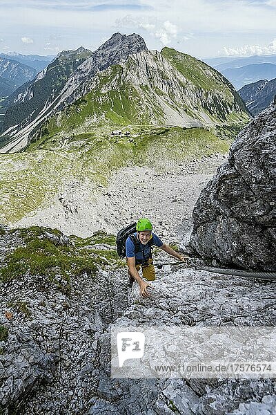 Junger Mann klettert im Klettersteig  Klettersteig Brudertunnel  Wanderweg zur Lamsenspitze  Unten Kessel mit Lamsenjochhütte  Karwendelgebirge  Alpenpark Karwendel  Tirol  Österreich  Europa