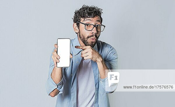 Young man showing blank cell phone screen  guy showing and pointing at his cell phone screen