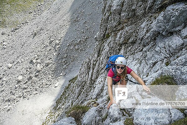 Junge Frau klettert an einer steilen Felswand  Lamsenspitze Klettersteig  Tirol  Österreich  Europa