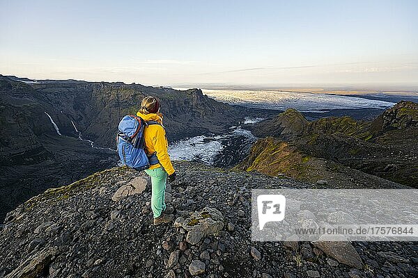 Wanderin blickt über spektakuläre Landschaft  Klippen und Gletscher Myrdalsjökull  Pakgil  Island  Europa
