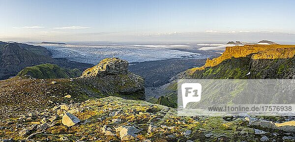 Wanderin in der Ferne auf einem Felsen  spektakuläre Landschaft  Klippen und Gletscher Myrdalsjökull  Pakgil  Island  Europa