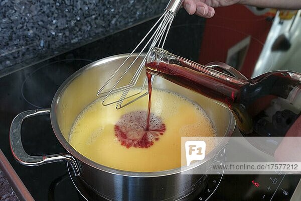 Schwäbische Küche  Zubereitung Arme Ritter  Rotwein in Kochtopf gießen zur Herstellung der Rotweinsauce  Süßspeise  Nachtisch  Dessert  Männerhände  Deutschland  Europa