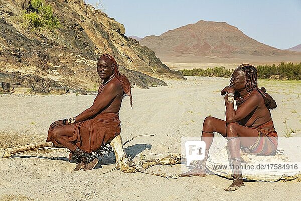 Himba-Frauen ruhen sich am Ufer des trockenen Flussbettes des Hoarusib-Flusses aus  Kaokoland  Kunene-Region  Namibia  Afrika