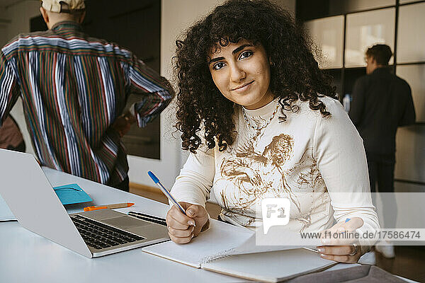 Portrait of young woman with curly hair studying at community college
