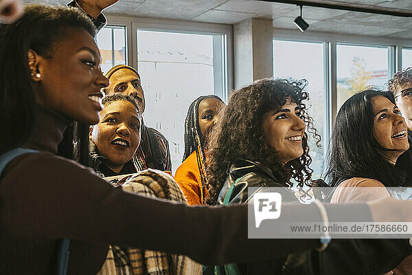 Lächelnde multirassische Studenten  die gemeinsam ihre Testergebnisse an der Universität überprüfen