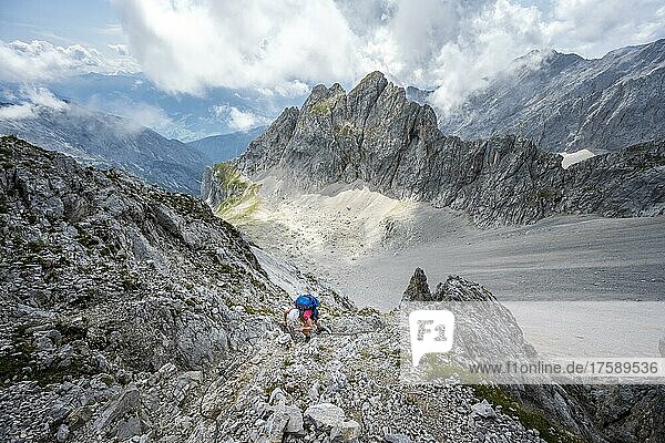 Hikers on the trail to Lamsenspitze  mountain basin and dramatic clouds  Karwendel Mountains  Tyrol  Austria  Europe