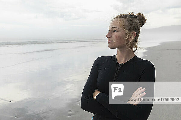 Portrait of girl (16-17) wearing wetsuit on Grotto Beach