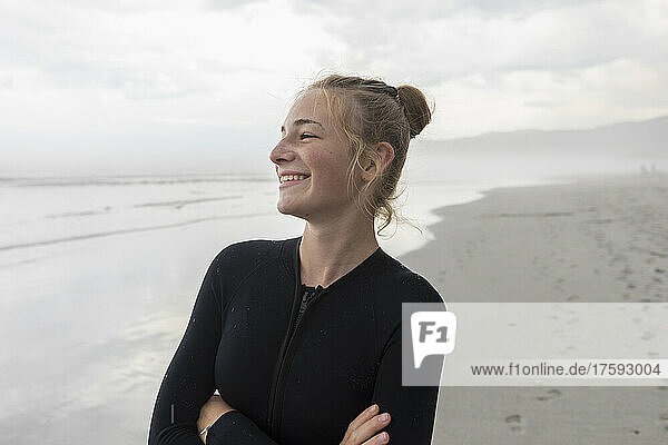 Portrait of girl (16-17) wearing wetsuit on Grotto Beach