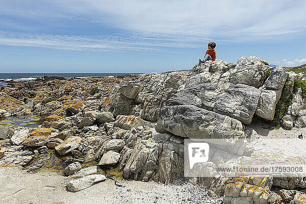 South Africa  Hermanus  Boy (8-9) exploring rocks on Sandbaai Beach