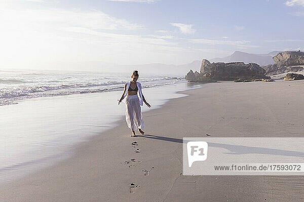 South Africa  Hermanus  Girl (16-17) walking on Sopiesklip beach in Walker Bay Nature Reserve