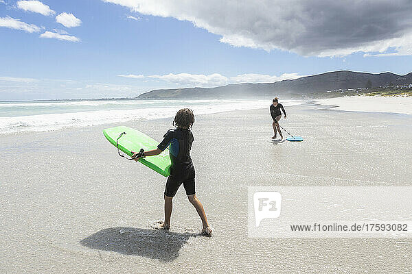 South Africa  Hermanus  Girl (16-17) and boy (8-9) with body boards on Grotto Beach