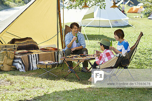 Japanese Family Talking At Campsite