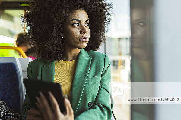 Thoughtful businesswoman looking through window of tram