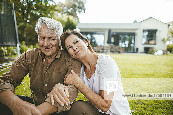 Lächelnder Mann und Frau sitzen zusammen im Hinterhof