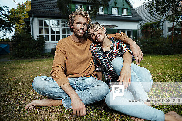 Couple sitting together on ground in garden