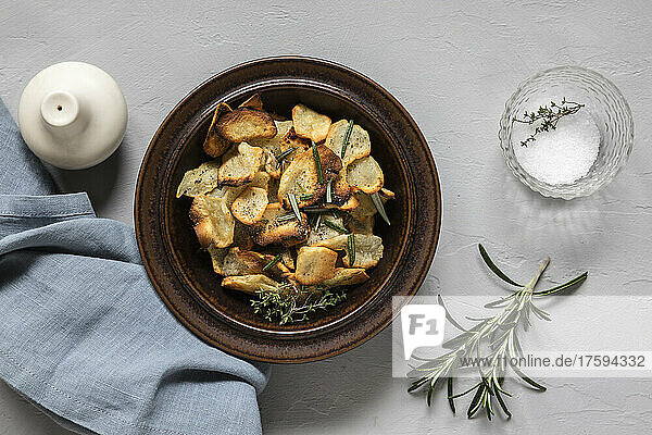 Jerusalem Artichoke chips and rosemary herb in bowl by salt
