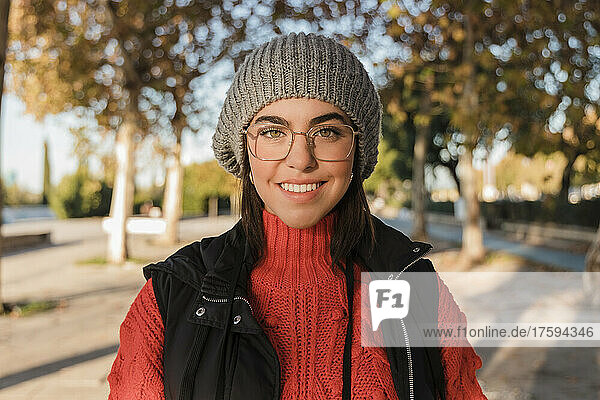 Happy young woman wearing knit hat and eyeglasses