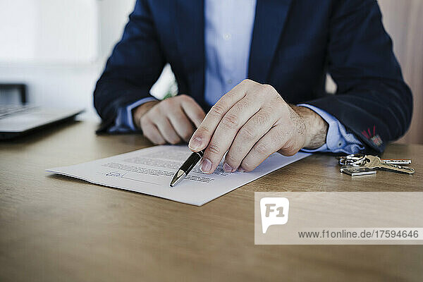 Real estate agent explaining contract on table in office