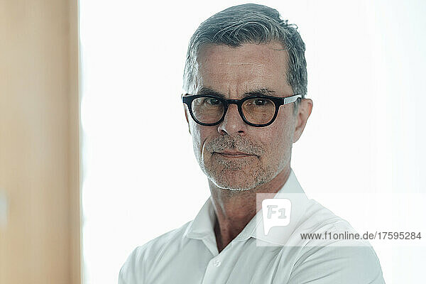 Confident businessman with eyeglasses at office
