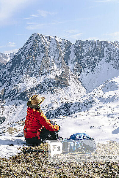 Frau in warmer Kleidung blickt auf schneebedeckte Berge  Naturschutzgebiet Kaukasus  Sotschi  Russland