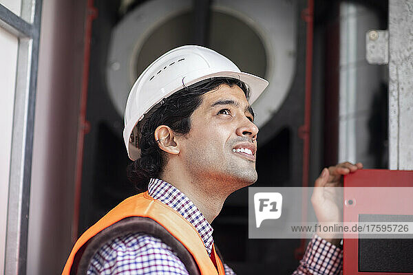 Engineer wearing hardhat working at machinery