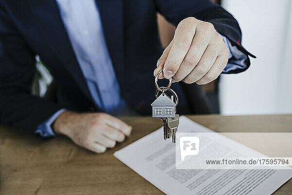 Businessman holding bunch of house keys in office