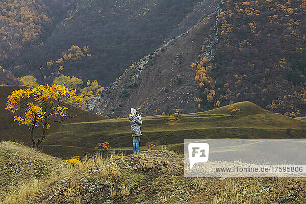 Woman standing on terraced field by mountains at North Caucasus  Dagestan  Russia