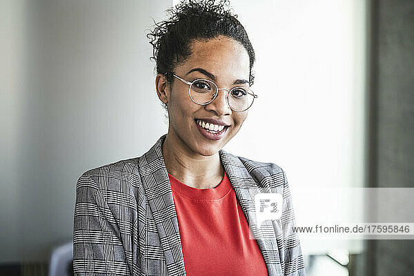 Smiling businesswoman with eyeglasses at work place