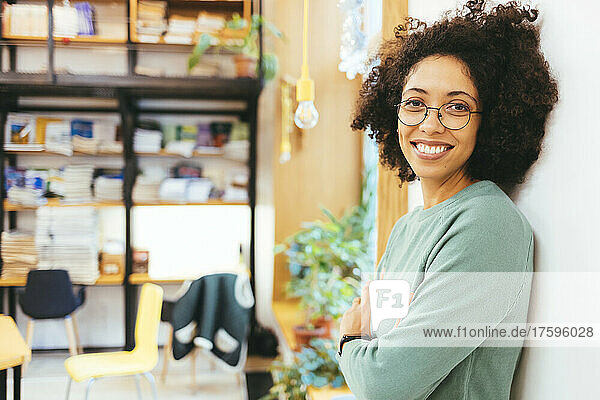 Smiling businesswoman with arms crossed in creative office