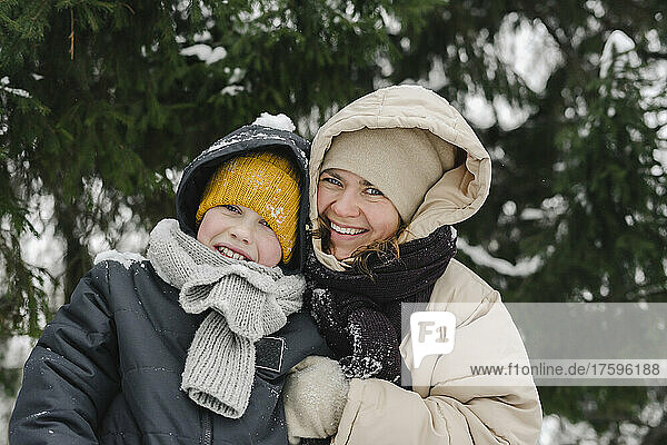Happy mother and son together at winter forest