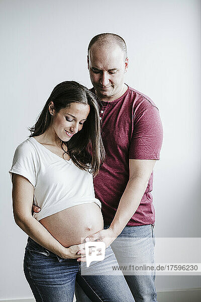 Man touching belly of pregnant wife at home