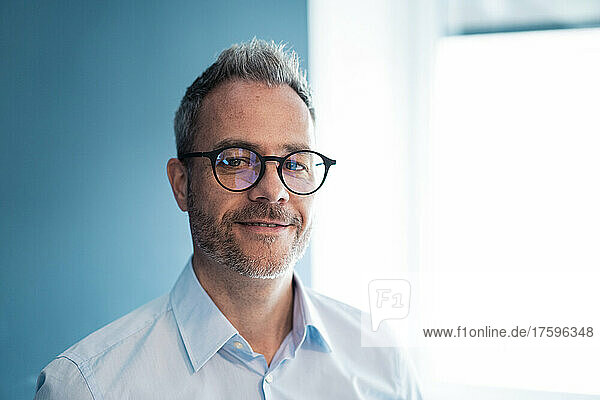 Smiling businessman wearing eyeglasses at workplace