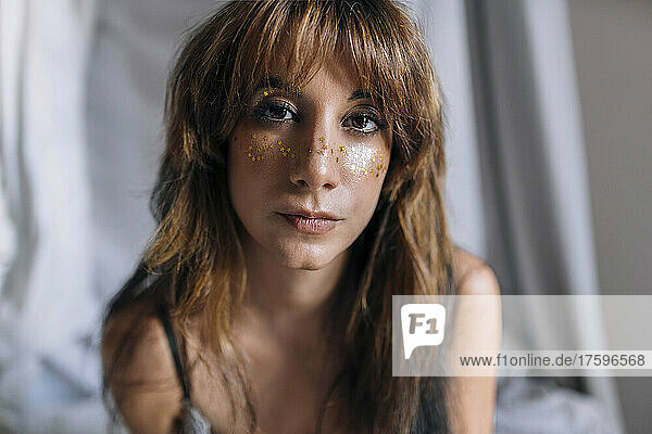 Young woman with glitter over face
