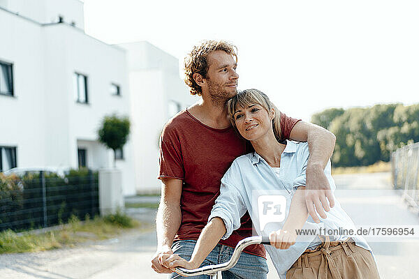 Nachdenklicher Mann und Frau mit Fahrrad auf Fußweg