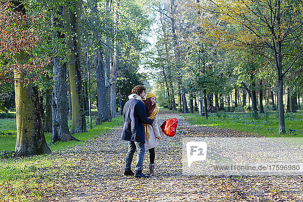 Glückliches Paar mit rotem Ballon  das im Park genießt
