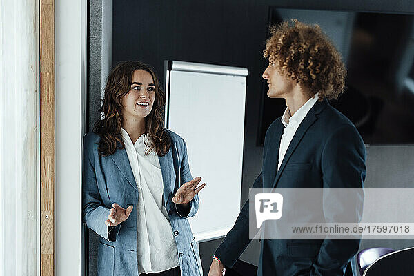 Young businesswoman discussing strategy with colleague in office