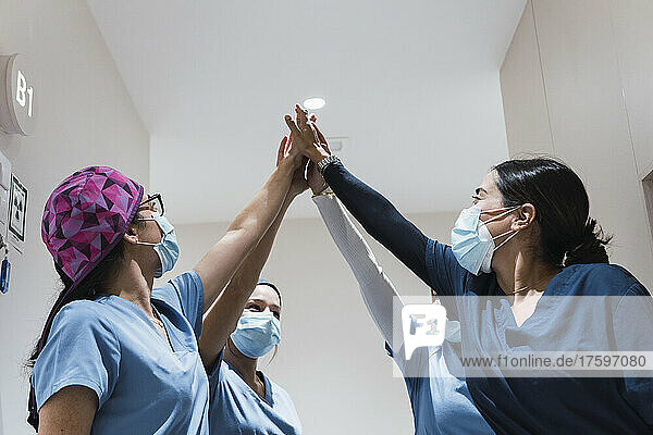 Doctors giving high-five to each other at hospital