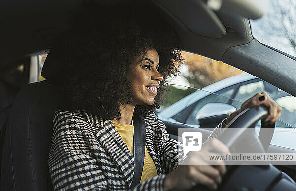 Smiling woman driving car on road trip