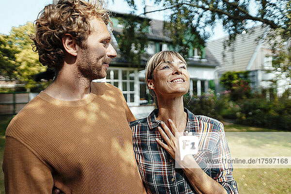 Young man looking at smiling woman in garden