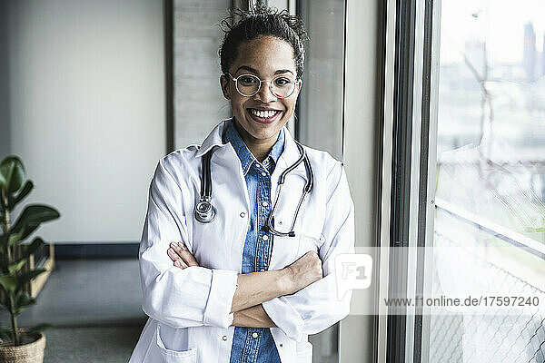 Smiling doctor with arms crossed in clinic