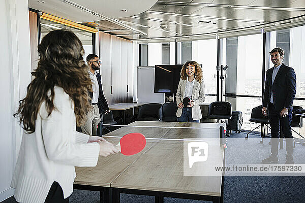 Businesswomen playing table tennis enjoying with colleagues in office