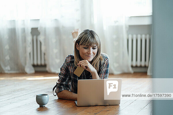 Smiling woman doing online shopping on laptop at home