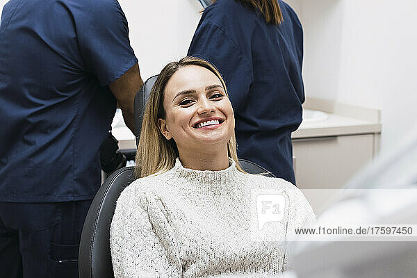 Smiling woman sitting on dentist chair at clinic