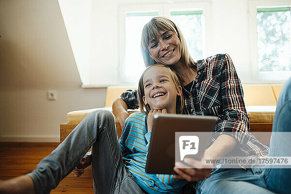 Mother and son with tablet PC laughing at home