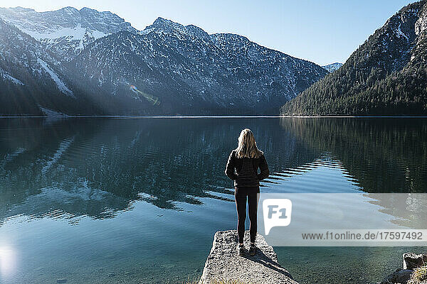 Woman looking across Lake Plansee to Ammergau Alps  Reutte  Tyrol  Austria