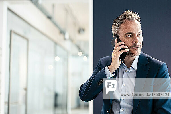 Businessman talking on mobile phone in office