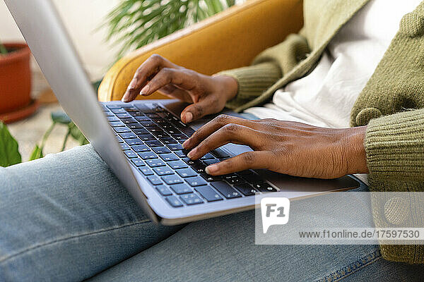 Freelance typing on laptop keyboard at home