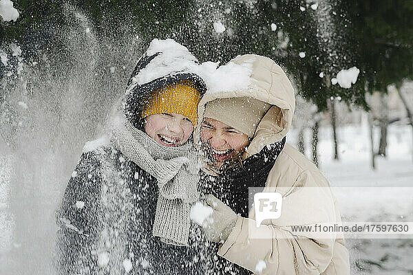 Cheerful son and mother enjoying in snow