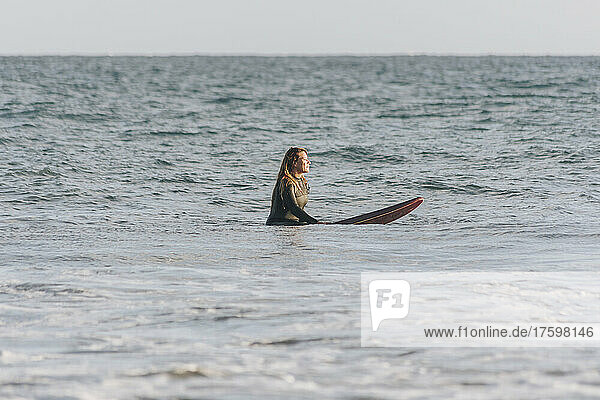 Woman with surfboard surfing in sea  Gran Canaria  Canary Islands