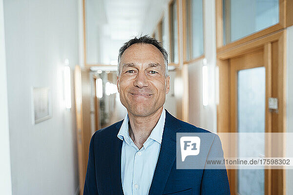 Smiling mature businessman at corridor in office